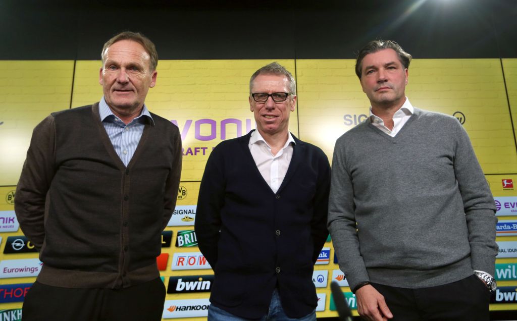 Peter Stoeger (C), new Austrian head coach of German first division Bundesliga club Borussia Dortmund, stands between Dortmund's managers Hans-Joachim Watzke (L) and Michael Zorc during a press conference where Stoeger is presented as the club's new head 