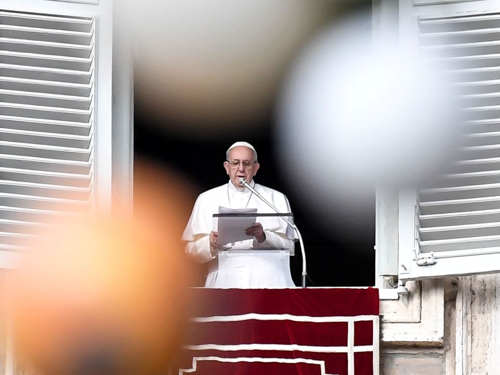 Pope Francis is pictured through the branches of a Christmas tree as he addresses the crowd from the Apostolic Palace overlooking St Peter's square during the Angelus prayer, on December 10, 2017 in Vatican. AFP / Andreas SOLARO

