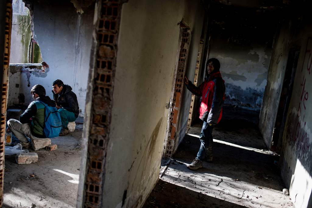 Migrants rest in an abandoned printing factory in the western Serbian town of Sid, on December 7, 2017. / AFP / Andrej ISAKOVIC