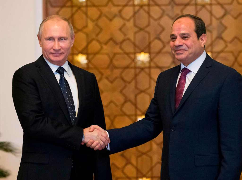 Russian President Vladimir Putin (L) shakes hands with his Egyptian counterpart Abdel Fattah al-Sisi upon his arrival at the presidential palace in the capital Cairo on December 11, 2017. / AFP / POOL / Alexander Zemlianichenko
