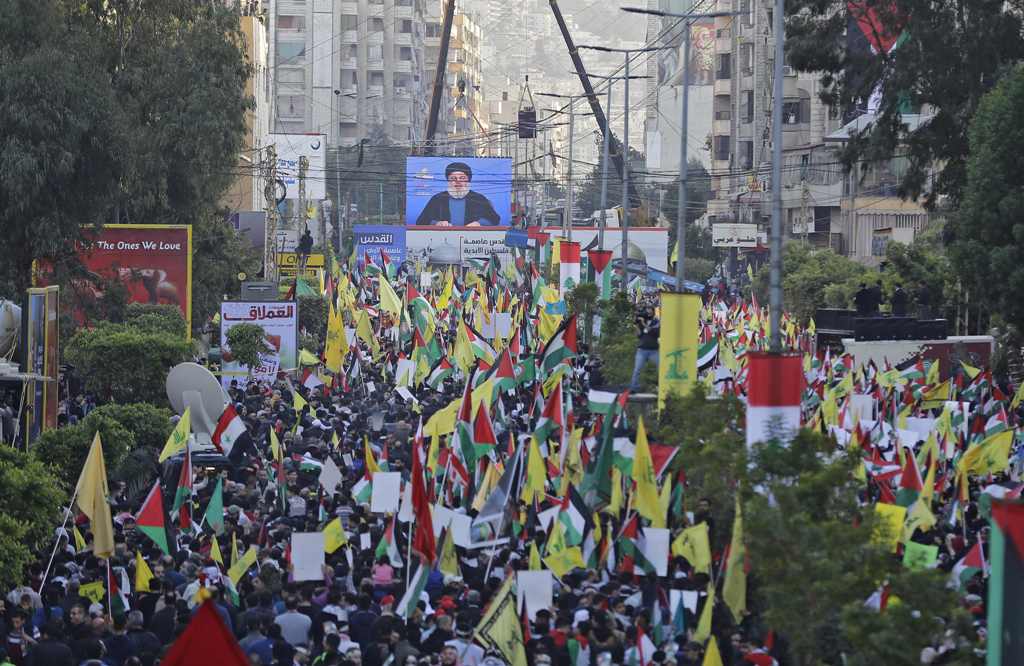 Lebanese demonstrators march with their national flags and the flags of Palestine and the militant Shiite movement Hezbollah during a protest against the US president's controversial recognition of Jerusalem as Israel's capital, in Beirut on December 11, 