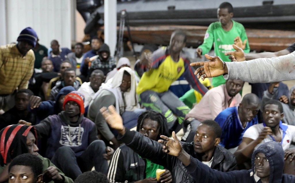 Migrants wait to receive food as they sit at Tripoli port after they were recuse by Libyan coast guards, in Tripoli, Libya December 13, 2017.  REUTERS/Hani Amara

