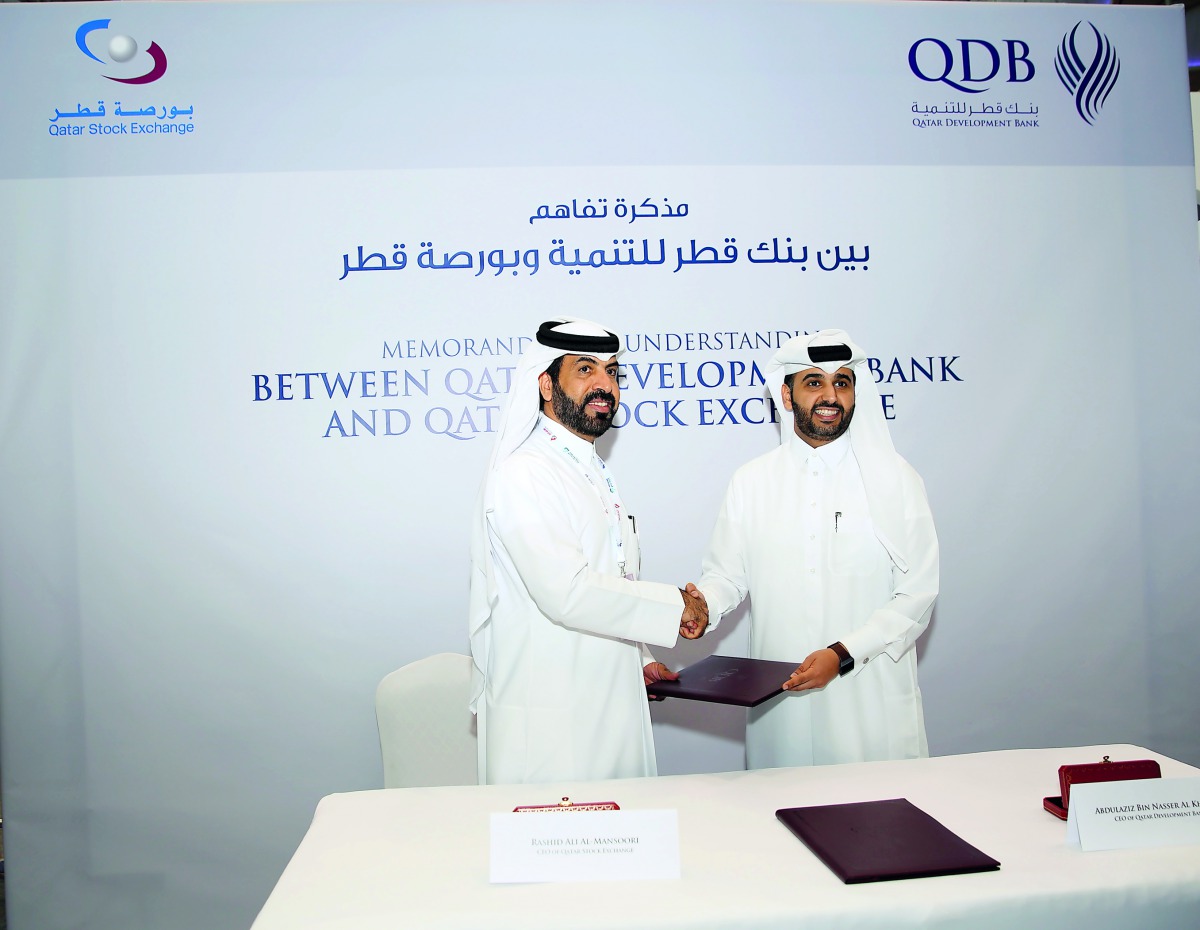 Rashid bin Ali Al Mansoori (left), CEO, Qatar Stock Exchange shakes hand with Abdulaziz Al Khalifa, CEO of Qatar Development Bank, after signing the agreement.