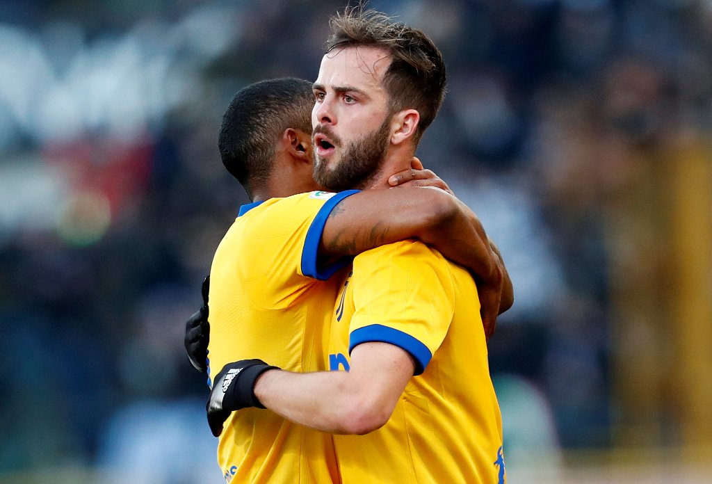 Juventus’ Miralem Pjanic celebrates with Douglas Costa after scoring their first goal from a free kick REUTERS/Alessandro Garofalo
