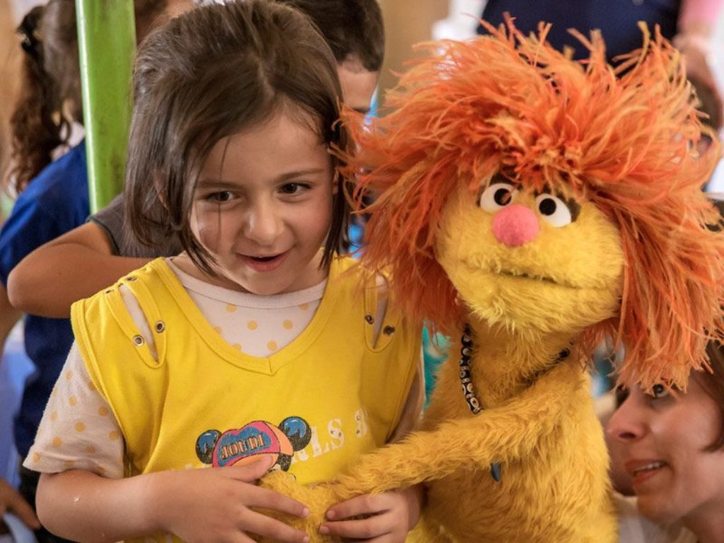 Sesame Muppet Tonton surprised a class of young students in an IRC classroom in the Bekaa Valley, Lebanon. Image from: http://refugee.sesameinternational.org/photo-gallery/