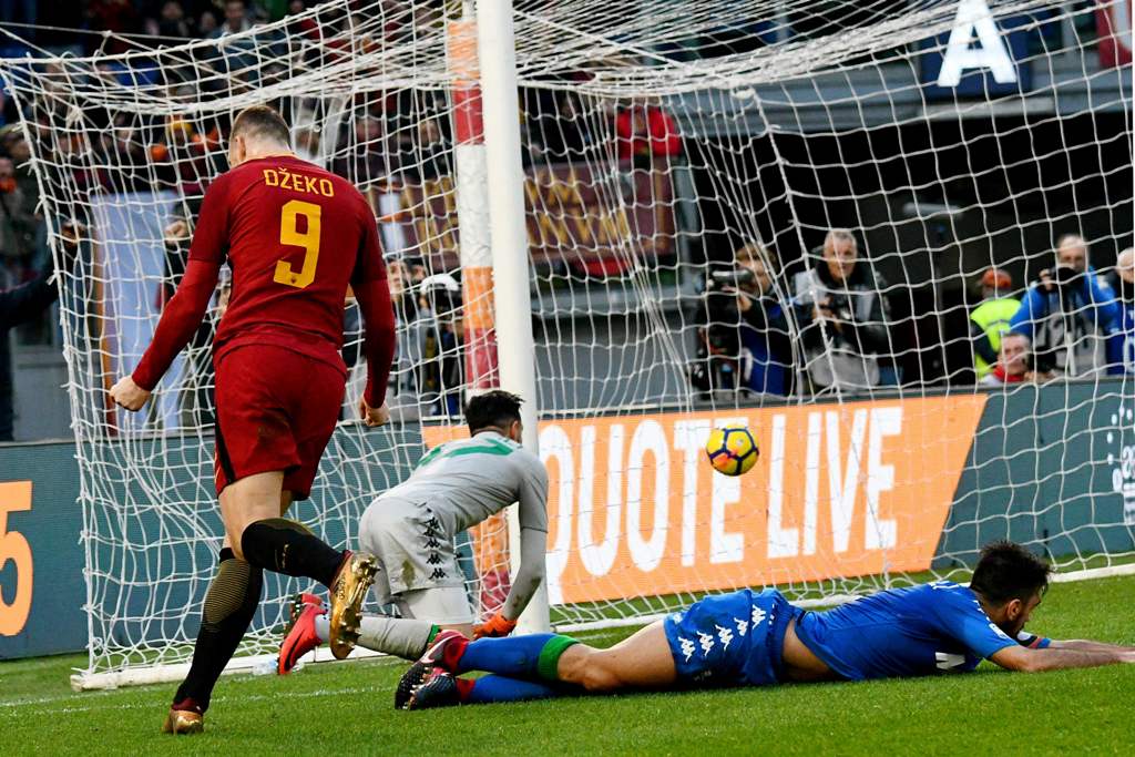 AS Roma's Bosnian forward Edin Dzeko (L) celebrates after scoring a goal later to be found invalid during the Italian Serie A football match AS Roma versus Sassuolo on December 30, 2017 at the Olympic stadium in Rome. / AFP / Vincenzo PINTO