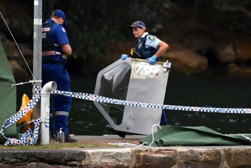A policewoman holds a piece of debris from the seaplane that crashed.PHOTO: REUTERS.