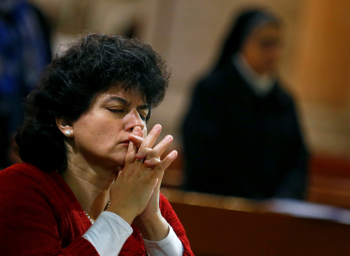 A woman prays during a New Year's Eve mass at Saint Joseph's Roman Catholic Church in Cairo, Egypt December 31, 2017. Reuters/Mohamed Abd El Ghany