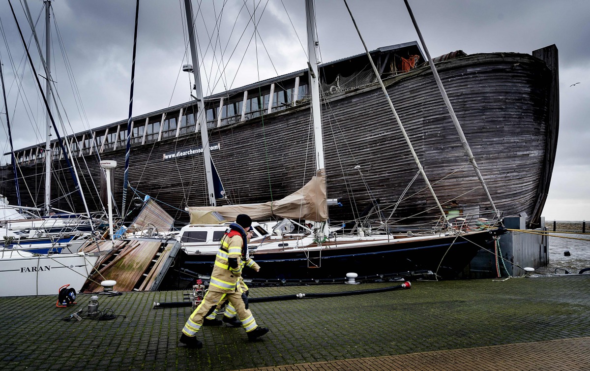 Workers walk past the Museum ship De VerhalenArk after it got loose in heavy winds at the harbour in Urk on January 3, 2018, as Storm Eleanor swept over the country. AFP / ANP / Robin van Lonkhuijsen