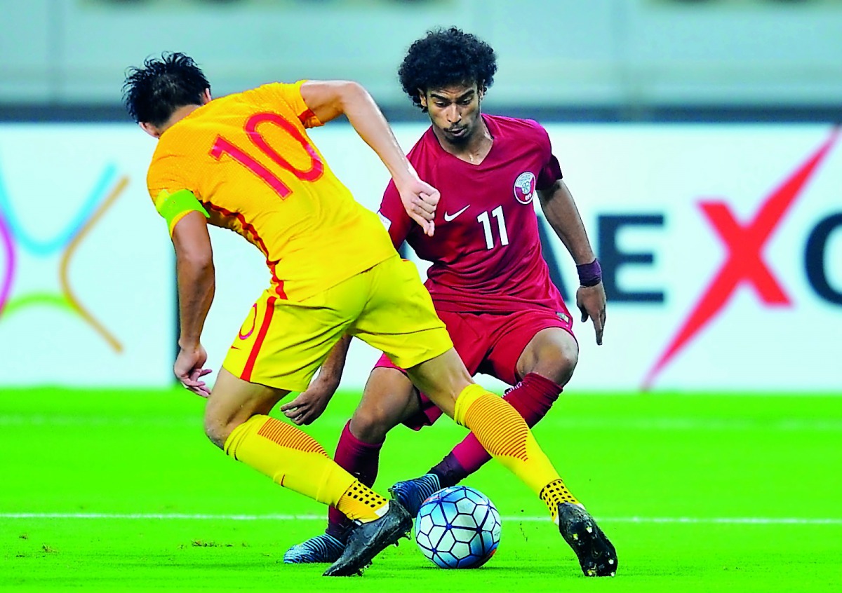 Akram Afif of Qatar attempts to break through Chinese defence during their FIFA World Cup 2018 qualifier which took place at the Khalifa International Stadium in Doha in this September 2017 file photo.