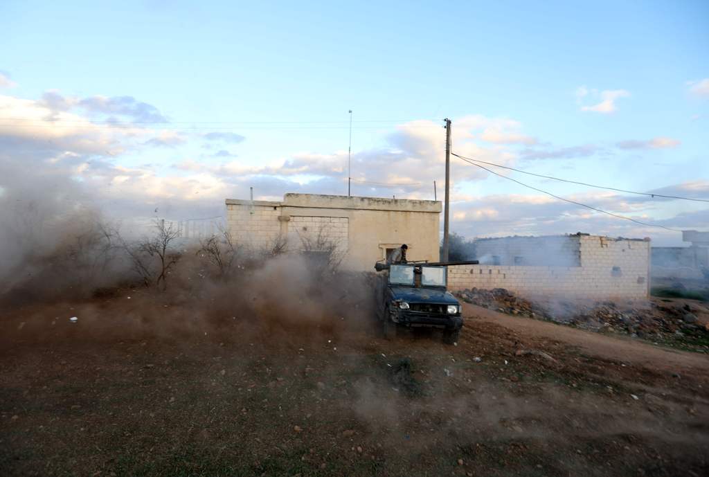 Opposition fighters drive in the village of Fureiji near al-Tamanah, in Syria's northwestern rebel-held province of Idlib, as they continue to battle government forces on January 2, 2018. / AFP / OMAR HAJ KADOUR
