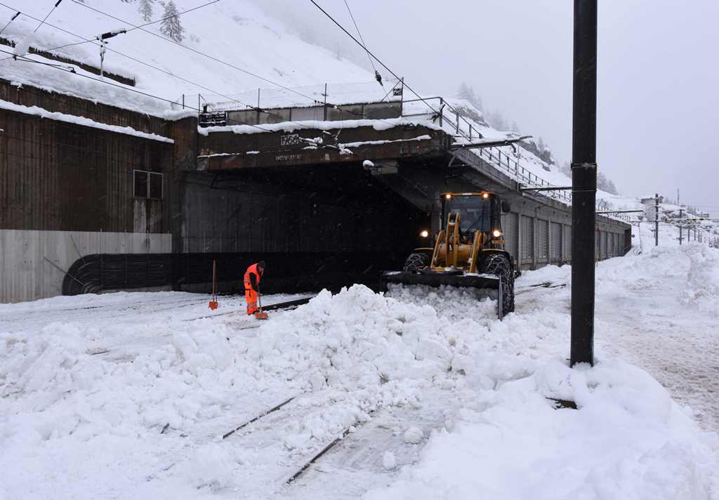 Workers clear snow from a train tunnel in Zermatt on January 9, 2018 after heavy snowfall and avalanches trapped more than 13,000 tourists at Zermatt, one of Switzerland's most popular ski stations. AFP / Mark Ralston
