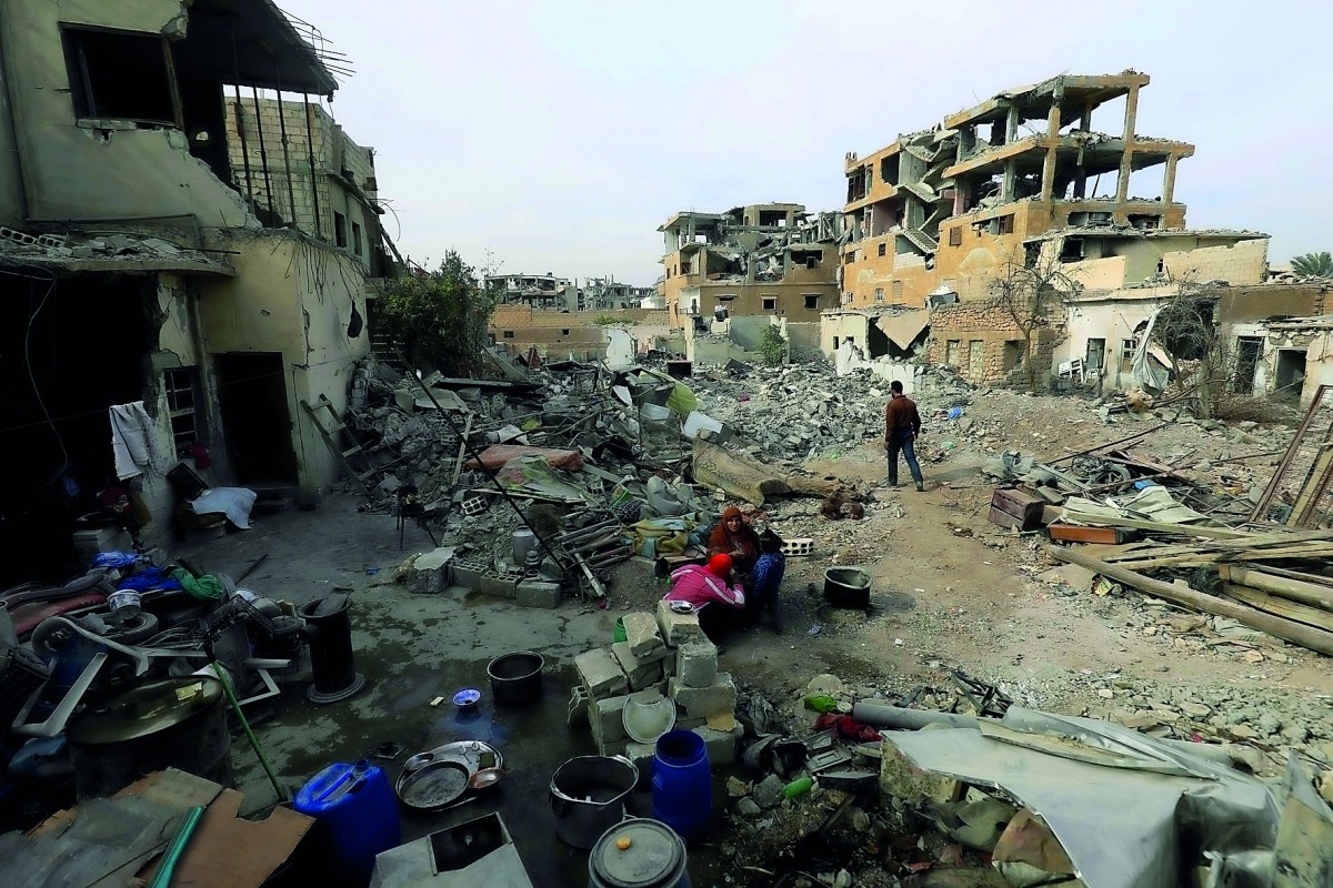 A Syrian family cooks amid the rubble in Raqqa, the former ‘capital’ of the Islamic State group in Syria, yesterday.