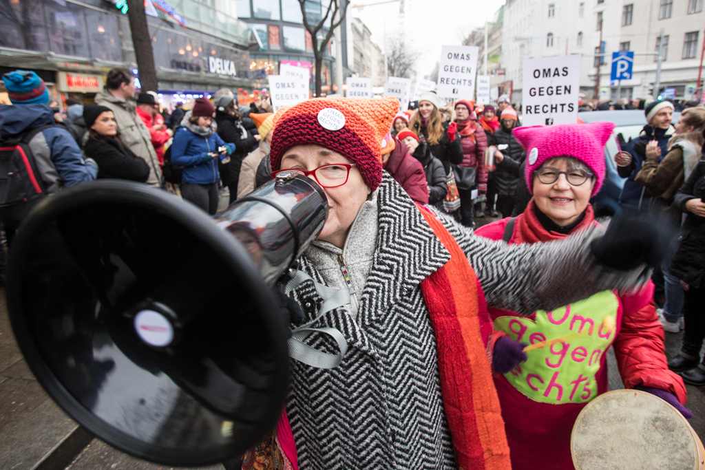 A protester wears a hat with a sticker reading 