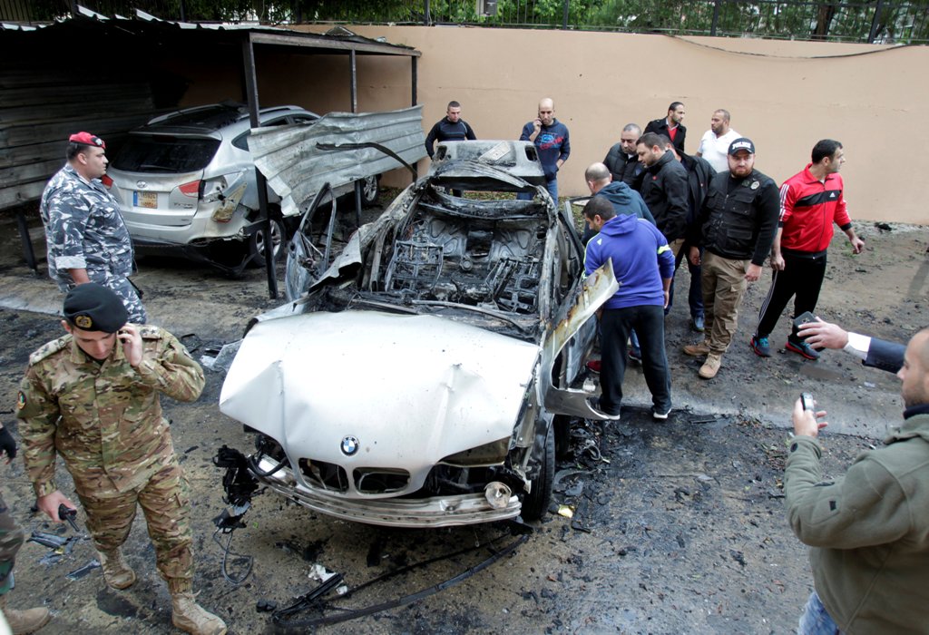 People inspect a damaged car in Sidon, southern Lebanon, January 14, 2018. REUTERS/Ali Hashisho