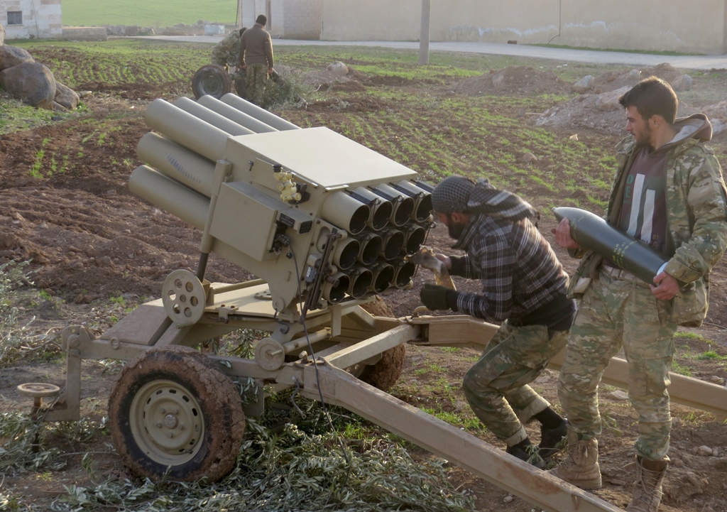 Two men prepare a multi-barrel rocket launcher within the clashes between armed opposition group Tahrir al-Sham and Assad Regime forces around the Abu Al-Duhur Military Airbase in a de-escalation zone in Idlib, Syria on January 13, 2018.Rasheed Hababa - A