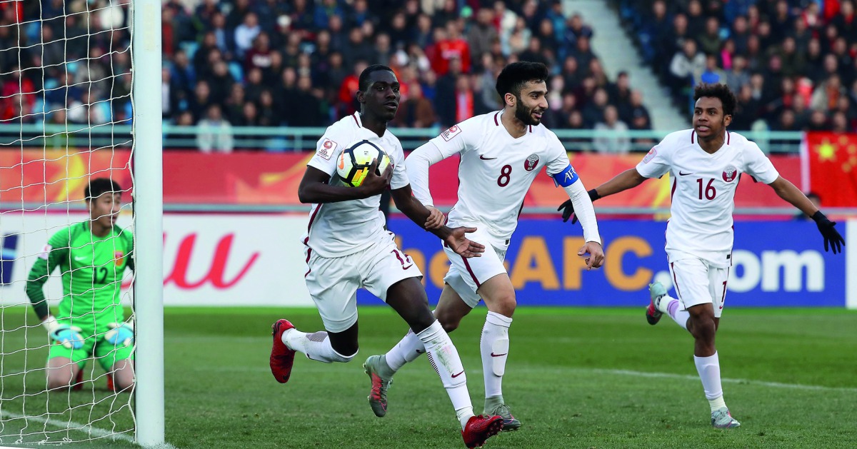 Qatari striker Almoez Ali carries the ball as he celebrates with team-mates  Ahmad Moein (centre) and  Hashim Ali (right) after scoring his first goal against China during their AFC U-23 Asian Cup match played in Changzhou, China yesterday.