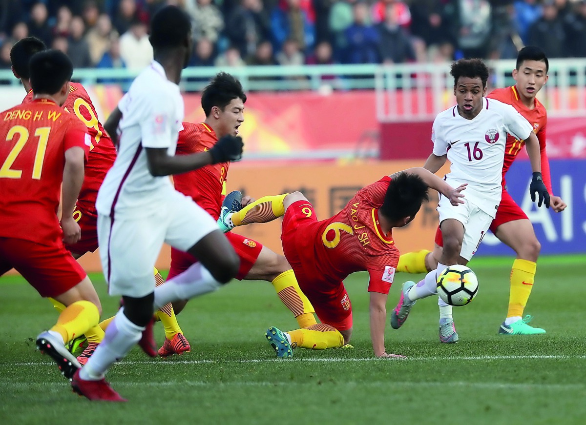 Qatari striker Almoez Ali carries the ball as he celebrates with team-mates  Ahmad Moein (centre) and  Hashim Ali (right) after scoring his first goal against China during their AFC U-23 Asian Cup match played in Changzhou, China yesterday.