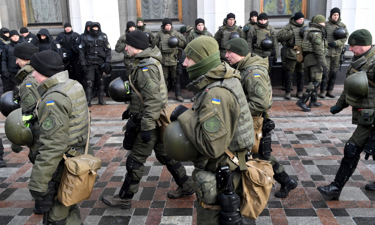Police officer stand guard as activists call for the deputies to recognise Russia as an aggressor state during a rally in front of the Ukrainian parliament in Kiev, on January 16, 2018.  AFP / Sergei Supinsky