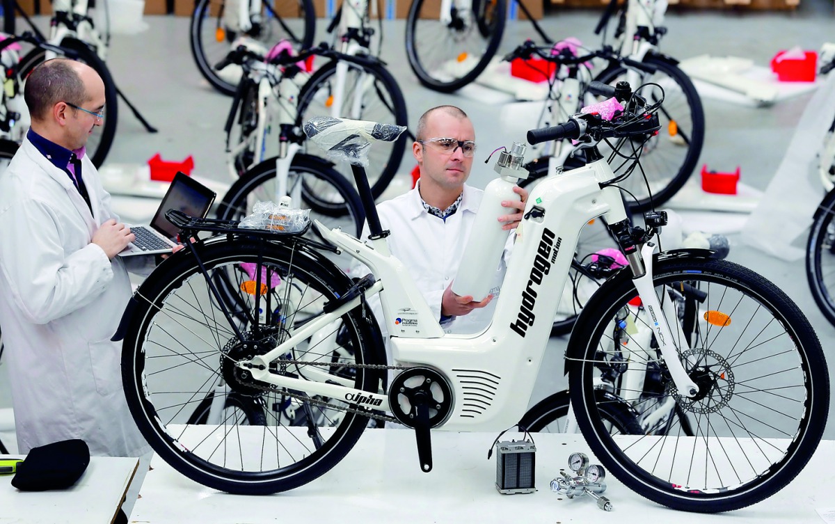 Pierre Forte (R), founder and CEO of Pragma Industries, and Alexandre Blanc (L), operations director, check an Alpha bike, first industrialised bicycle to use a hydrogen fuel cell at the Pragma Industries factory in Biarritz, France, January 15, 2018. Pic