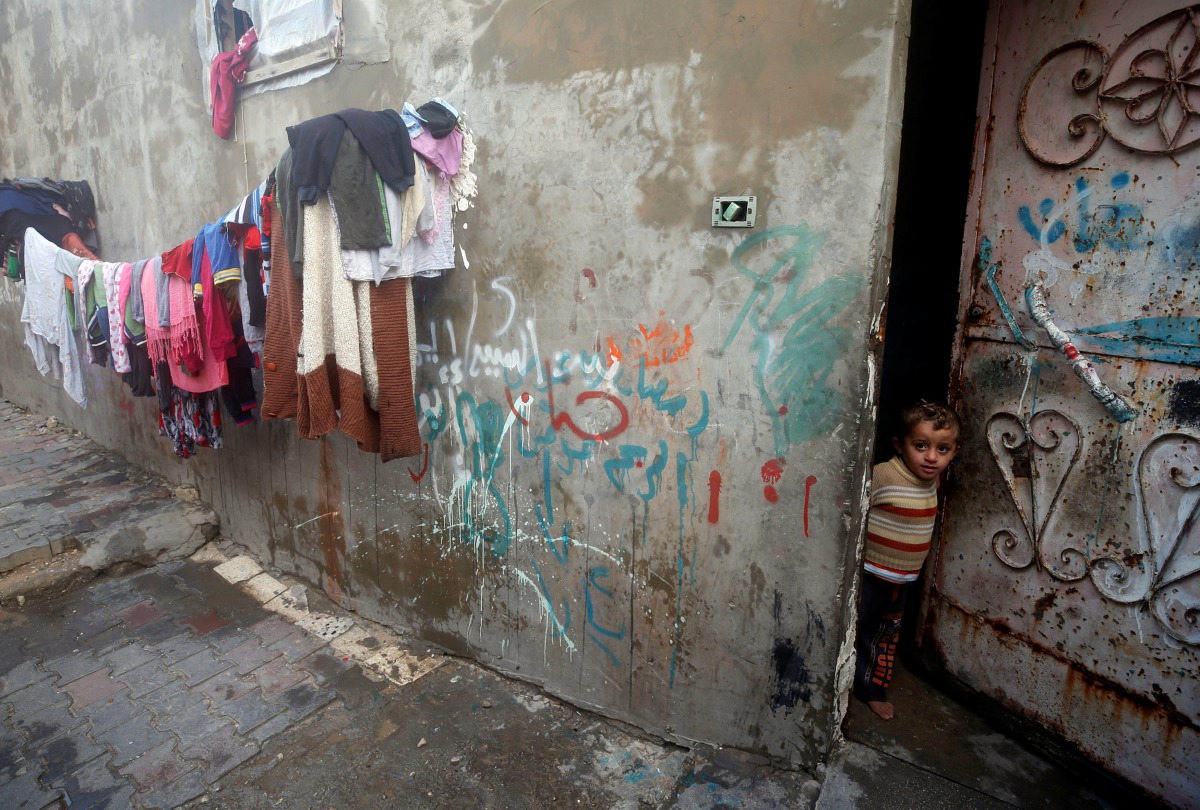 A Palestinian boy looks out of his family's house in Al-Shati refugee camp in Gaza City January 15, 2018. Picture taken January 15, 2018. Reuters/Mohammed Salem