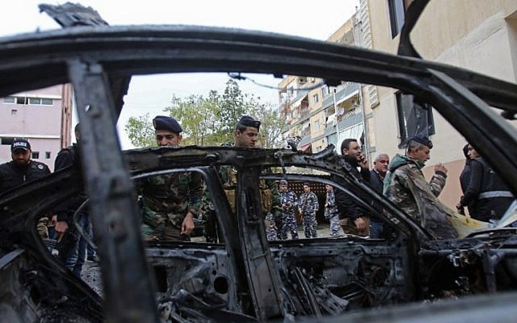 Lebanese security forces check a damaged vehicle following a car bomb blast in the southern Lebanese. AFP