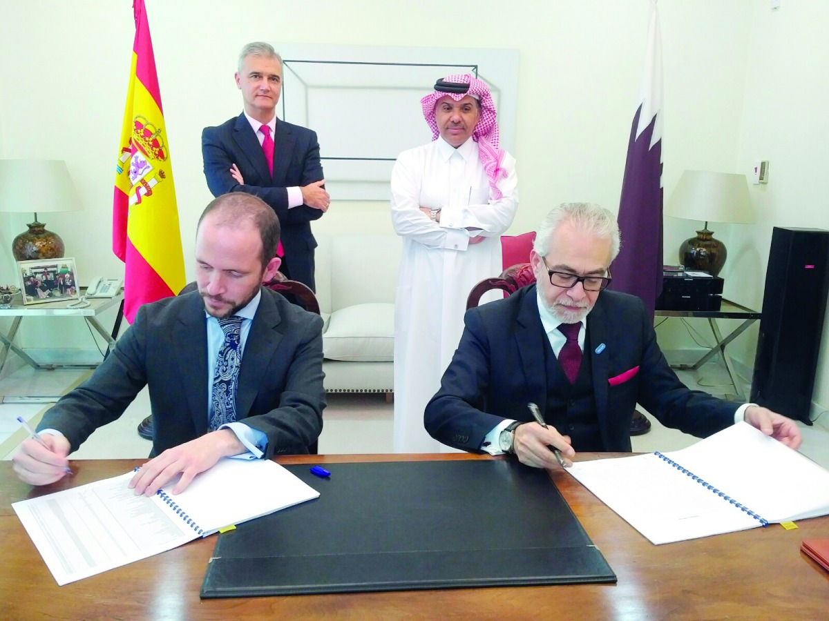 IIgnacio Escobar (left, standing), Spain’s ambassador to Qatar and Ahmed Rafea Al Emadi (right, standing), CEO of Al Koot Insurance and Reinsurance Company, look on as, Jehad Badreddin Rahima (right, sitting) Chief Officer Health and Life at Al Koot Insur