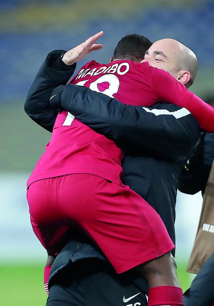 Jubilant Qatari player Assim Madibo embraces coach Felix Sanchez after their win against South Korea in the AFC U-23 Asian Cup third place play-off match in Kunshan, China  