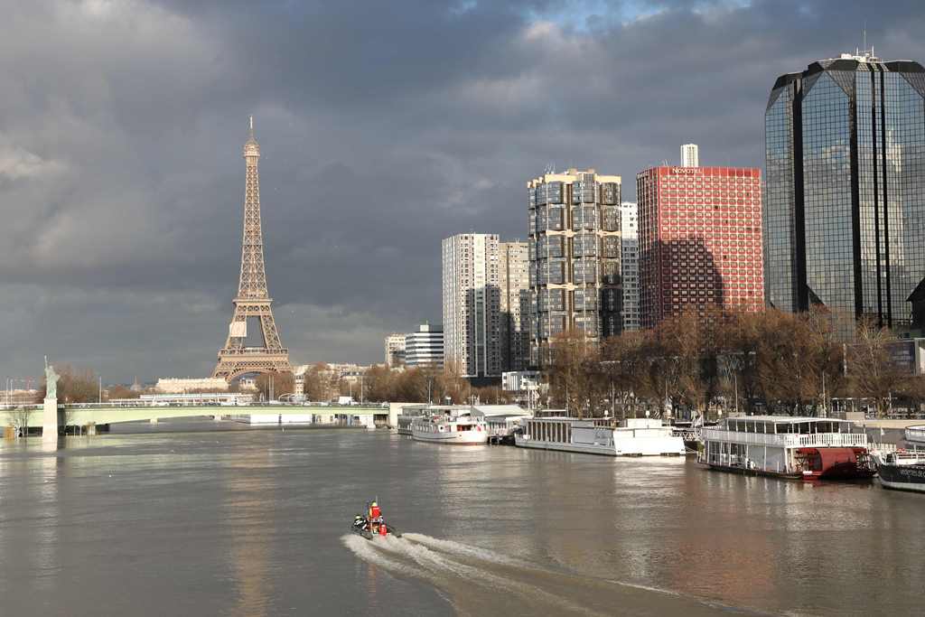 A picture taken on January 26, 2018, shows the flooded banks of the river Seine and the Beaugrenelle area and Eiffel Tower in the backround in Paris. AFP / Ludovic Marin 