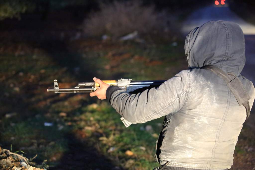 A picture taken on January 26, 2018, shows a member of the Kurdish People's Protection Units (YPG) militia standing guard in the fields outside the Kurdish town of Jandairis near the Syrian-Turkish border, west of the city of Afrin. / AFP / STRINGER