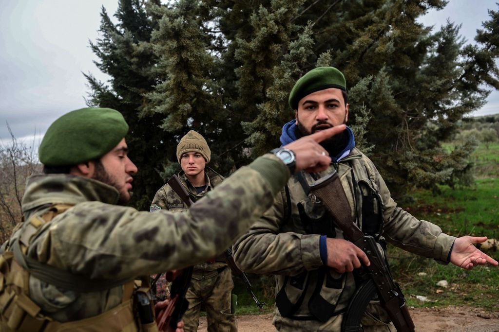 Turkish-backed Syrian rebel fighters take a position as they stand guard near the frontline on January 26, 2018 at the Syrian town of Azaz.  AFP / OZAN KOSE