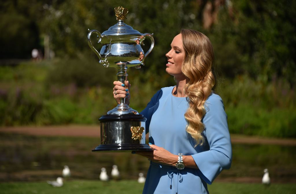 Denmark's Caroline wozniacki holds up the trophy during a photocall at the Royal Botanical Gardens in Melbourne on January 28, 2018, a day after beating Romania's Simona Halep in their women's singles final match at the Australian Open tennis tournament. 