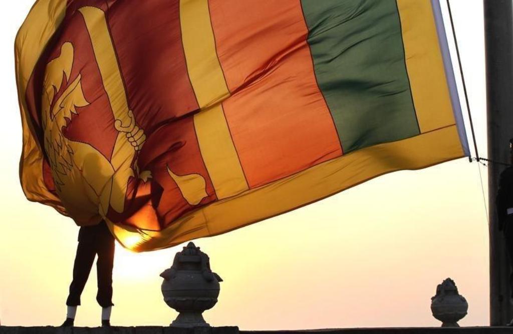 File photo of an air force officer holding Sri Lanka's national flag as the sun sets at Galle Face Green in Colombo February 2, 2013. REUTERS/Dinuka Liyanawatte