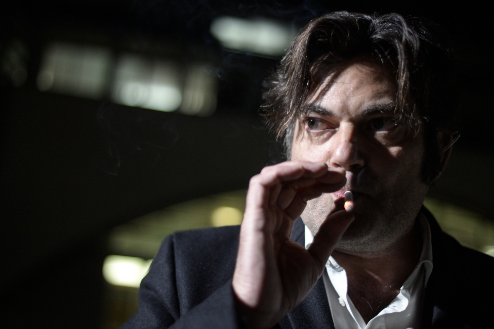 Jonathann Daval's lawyer, Randall Schwerdorffer, smokes as he poses during a photo session, in Besancon on January 30, 2018, after Daval has admitted to killing his wife, Alexia Daval, by accident. AFP / Sebastien Bozon