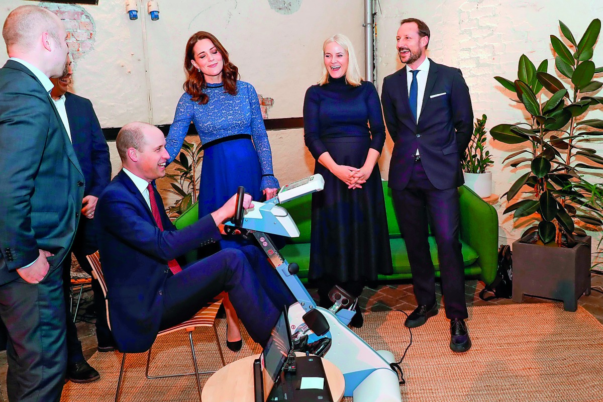 Britain's Prince William, Duke of Cambridge, rides on an apparatus while Britain's Catherine, Duchess of Cambridge, Norway's Crown Princess Mette-Marit and Norway's Crown Prince Haakon react during a visit at MESH, the Nordic Creators’ Community in Oslo, 