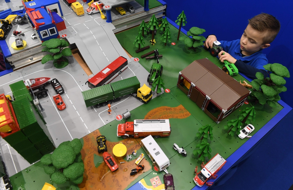 A young boy plays with cars at a booth during the press preview of the international toys fair Spielwarenmesse in Nuremberg, Southern Germany, on January 30, 2018. AFP / CHRISTOF STACHE