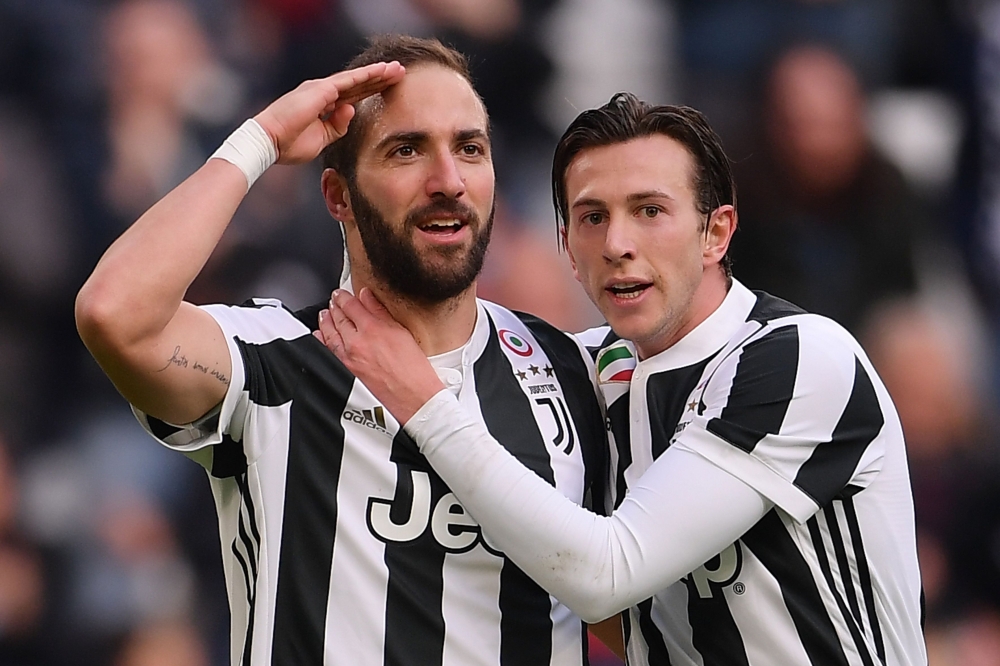 Juventus' Argentinian forward Gonzalo Higuain (L) celebrates with his teammate Juventus' Italian midfielder Federico Bernardeschi (R) after scoring a goal during the Italian Serie A football match between Juventus and Sassuolo on February 4, 2018 at the '