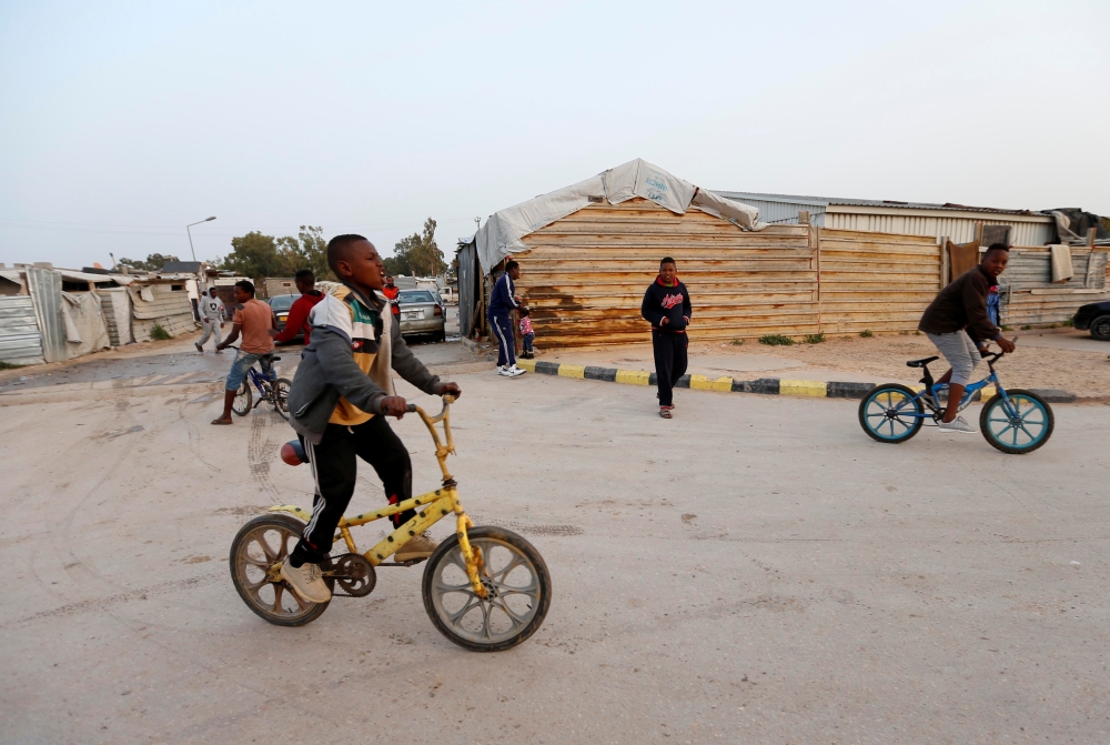 Libyan boys displaced from the town of Tawergha ride bicycles at a camp in Tripoli, Libya, February 5, 2018.  Reuters/Ismail Zitouny