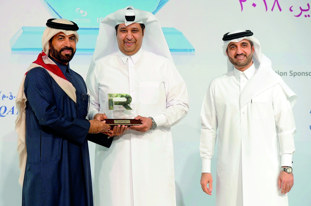 Rashid bin Ali Al Mansoori (left), CEO of QSE giving away the award to QNB official at the 3rd Annual IR Excellence Program,  as Abdul Aziz Al Emadi, Director, Listing Department of QSE, looks on. 
Pic : Abdul Basit