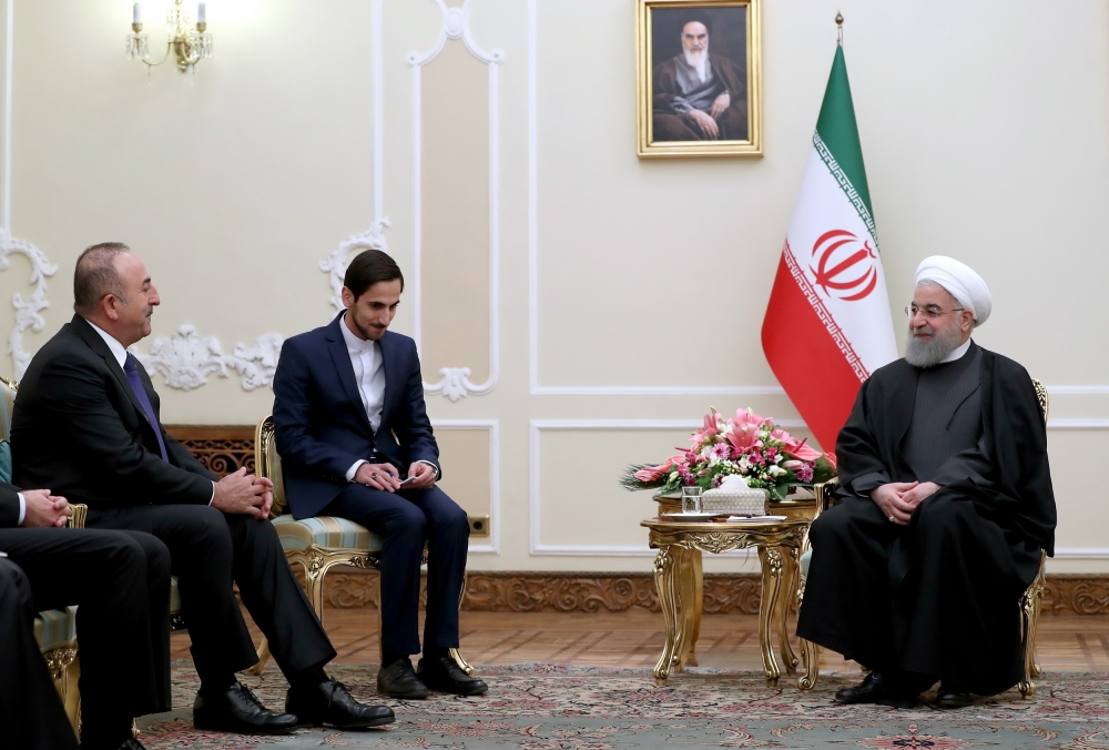 A handout picture provided by the Iranian presidency official website on February 7, 2018 shows President Hassan Rouhani (R) meeting with Turkish Foreign Minister Mevlut Cavusoglu (L) in the capital in Tehran. AFP PHOTO / HO / IRANIAN PRESIDENCY