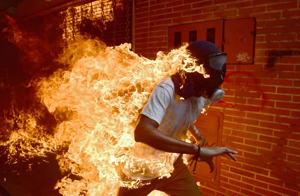(FILES) In this file photo taken on May 03, 2017 A demonstrator catches fire during clashes with riot police within a protest against Venezuelan President Nicolas Maduro. AFP / RONALDO SCHEMIDT