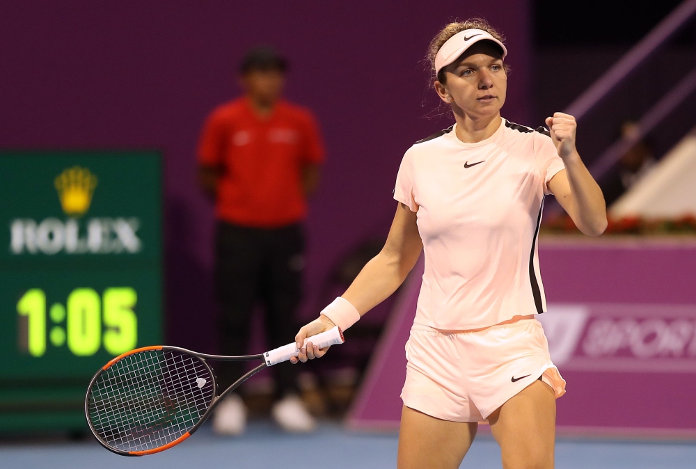Romanian tennis player Simona Halep reacts after playing a point against Russian player Ekaterina Makarova as they compete in their singles match during the second round of the Qatar Open tennis competition in Doha on February 14, 2018. / AFP / KARIM JAAF