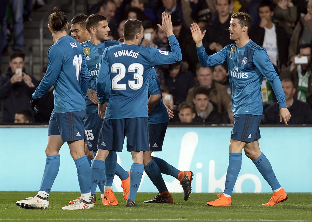 Real Madrid's French forward Real Madrid's Portuguese forward Cristiano Ronaldo (R) celebrates scoring a goal with teammates during the Spanish league football match Real Betis vs Real Madrid at the Benito Villamarin stadium in Sevilla on February 18, 201