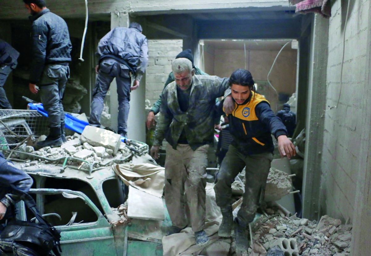 Syrian rescuers work at site of Syrian government bombardments in Douma, in the besieged Eastern Ghouta region on the outskirts of the capital Damascus on February 22, 2018.  AFP / Hamza Al-Ajweh