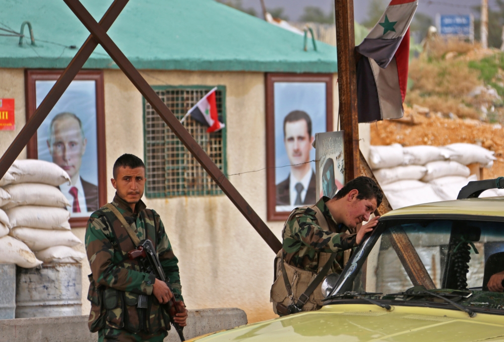 Members of the Syrian government forces stand at the Wafideen checkpoint on the outskirts of Damascus neighbouring the rebel-held Eastern Ghouta region on February 27, 2018 during an operation that would allow some of the nearly 400,000 people living in t