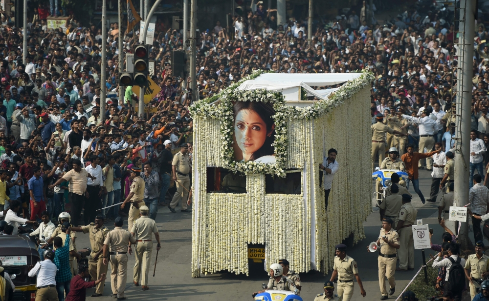 Indian fans watch as the funeral cortege of the late Bollywood actress Sridevi Kapoor passes through Mumbai on February 28, 2018. / AFP / PUNIT PARANJPE 