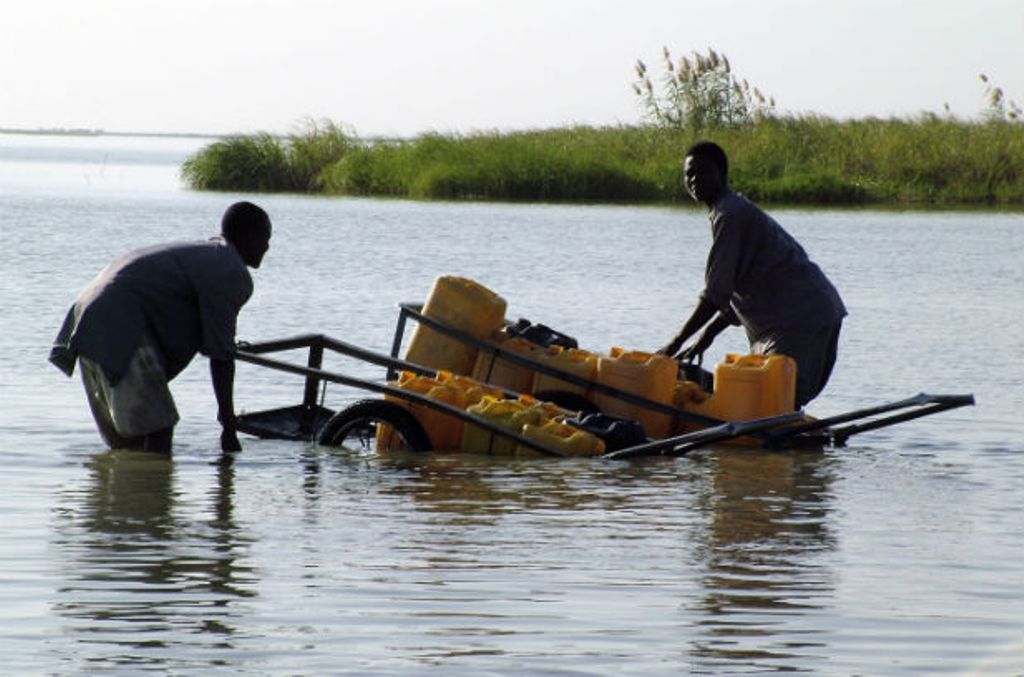 (FILE PHOTO) Chadian men collect water with plastic canisters loaded on a handcart in Lake Chad. Reuters
