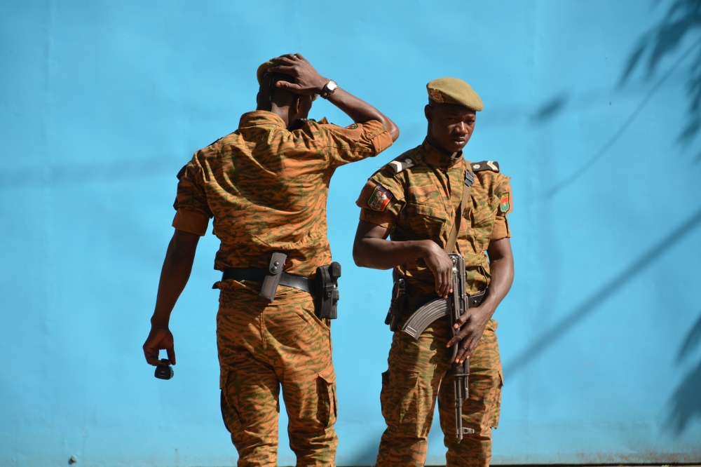 Burkinabe men patrol the army's headquarters from the roof in Ouagadougou on March 3, 2018 a day after dozens of people were killed in twin attacks on the French embassy and the country's military.   AFP / Ahmed OUOBA
