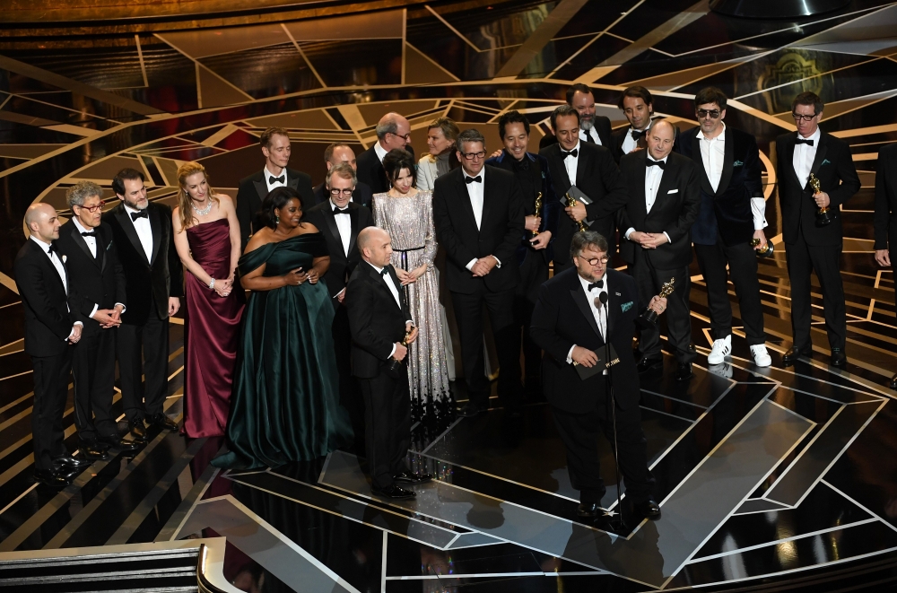 Producer J. Miles Dale (L), director Guillermo del Toro (at microphone) and cast/crew accept Best Picture for 'The Shape of Water' onstage during the 90th Annual Academy Awards at the Dolby Theatre at Hollywood & Highland Center on March 4, 2018 in Hollyw