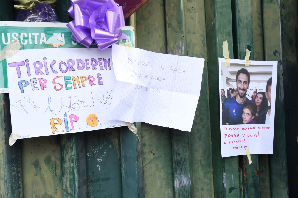 Football fans hang scarves and homages to late Fiorentina's captain Davide Astori on the fence of Fiorentina's stadium, on March 4, 2018 in Florence.  AFP / Claudio GIOVANNINI

